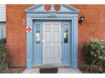 Inviting townhouse front door with brick exterior and attractive blue accents at 7340 Daniel Webster Dr # 7, Winter Park, FL 32792