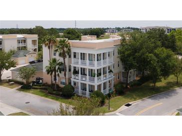 Three-story building with balconies, palm trees, and street view at 7521 Mourning Dove Cir # 303, Reunion, FL 34747