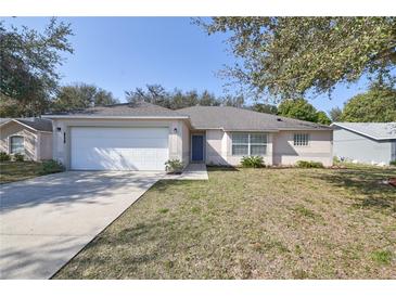 Charming single-story home with a well-manicured lawn and two-car garage at 1001 Willow Run St., Minneola, FL 34715