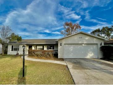 Single story home with attached garage and well-maintained lawn at 115 Cardamon Dr, Orlando, FL 32825