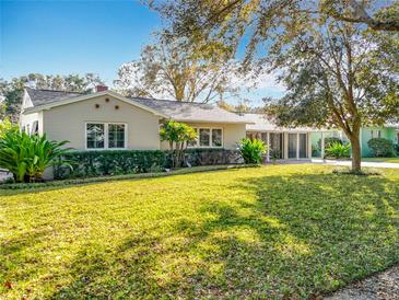 Charming home showcasing a well-manicured lawn with mature trees, lush landscaping, and inviting curb appeal at 1250 Chichester St, Orlando, FL 32803