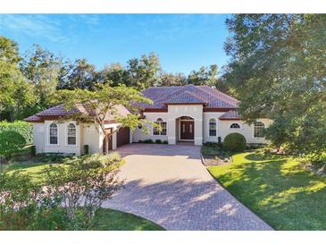 Single-story home with tile roof, large driveway, and lush landscaping at 1829 Brackenhurst Pl, Lake Mary, FL 32746