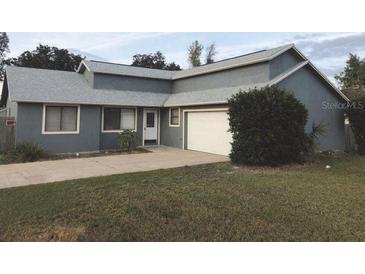 View of the home's front featuring gray exterior paint, new roof, and attached garage at 1886 Elkcam Blvd, Deltona, FL 32725
