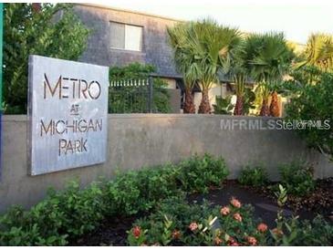 Community sign for Metro at Michigan Park amid lush landscaping and mature trees in front of the building at 1928 Conway Rd # 40, Orlando, FL 32812