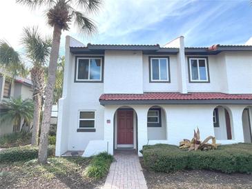 Two-story stucco home with red tile roof and landscaped walkway at 3187 Sea World Ct, Kissimmee, FL 34746
