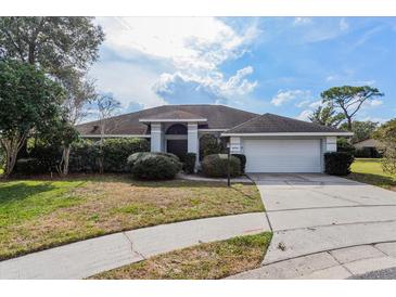 Charming single-story home with a well-manicured lawn, mature trees, and an attached two-car garage at 4001 Misty Morning Pl, Casselberry, FL 32707