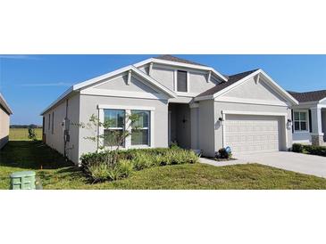 Beautiful one-story home with a two-car garage and manicured lawn at 648 Daring Dr, Davenport, FL 33837