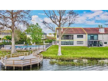 Waterfront home with balcony, community pool, private dock, and lush lawn at 660 Killarney Bay Ct # 6, Winter Park, FL 32789