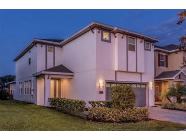 Contemporary two-story home with manicured landscaping, neutral color scheme, and attached garage at 7623 Wilmington Loop, Kissimmee, FL 34747