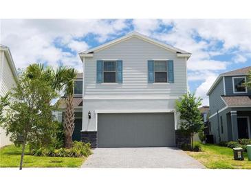Two-story house featuring gray siding, gray garage door, and blue shutters at 2472 Dubai St, Kissimmee, FL 34747