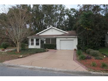 Charming single-story home with an attached garage, well-maintained lawn, and mature landscaping at 32512 Oak Park Dr, Leesburg, FL 34748