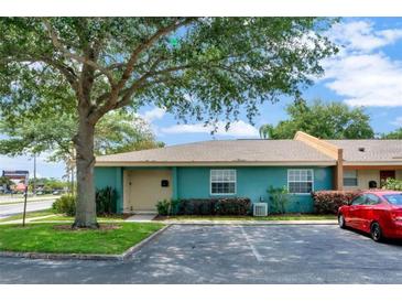 Cute teal exterior of condo with a tree and parking at 4768 Tangerine Ave # 4768, Winter Park, FL 32792