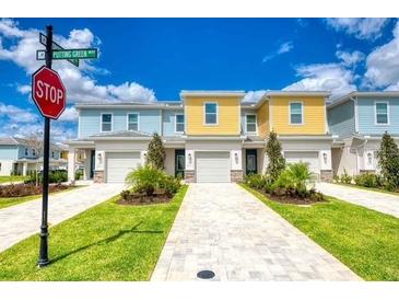 Charming townhomes feature colorful exteriors, well-manicured lawns, and paved driveways under a sunny sky at 7925 Putting Green Way, Reunion, FL 34747