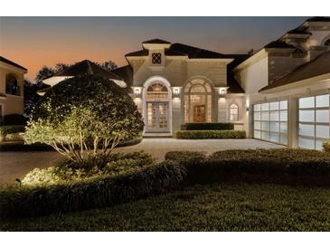 Elegant two-story home with a manicured lawn and a three-car garage at 8148 Tibet Butler Dr, Windermere, FL 34786
