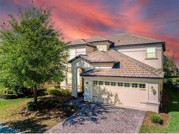 Two-story house with a three-car garage and a landscaped front yard at 9024 Shadow Mountain St, Davenport, FL 33896