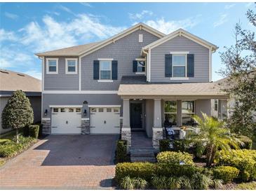 Two-story home with gray siding, two-car garage, and landscaped yard at 9459 Jaywood Rd, Winter Garden, FL 34787