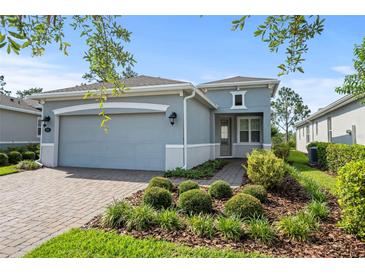 Single-story home with gray exterior, two-car garage, and landscaped front yard at 1069 Avery Meadows Way, Deland, FL 32724