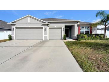 Two-story house with three car garage and landscaped yard at 15267 Aquarius Way, Mascotte, FL 34753