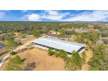 Aerial view of equestrian property with large arena, barns, and paddocks at 2140 W State Road 46, Geneva, FL 32732