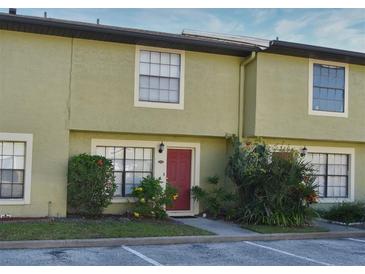 Charming townhome with neutral paint, red door, and manicured landscaping at 3208 Oak Lawn Pl # 218, Winter Park, FL 32792
