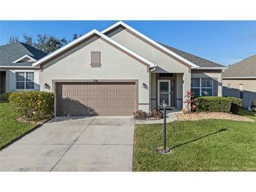 Charming single-story home with a two-car garage, well-maintained landscaping, and neutral-colored stucco exterior at 3608 Mount Hope Loop, Leesburg, FL 34748