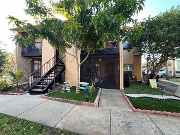 Updated condo with exterior features including a staircase and landscaped area at 4854 S Semoran Blvd # 2203, Orlando, FL 32822