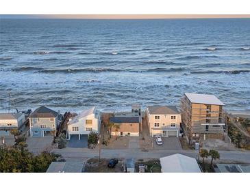 An aerial view of beachfront homes, offering a prime coastal living experience with ocean views and private beach access at 6877 S Atlantic Ave, New Smyrna Beach, FL 32169