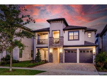 Two-story house with gray exterior, two-car garage, and stone accents at 1039 Jack Nicklaus Ct, Kissimmee, FL 34747