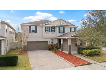 Two-story house with a brown garage door and landscaped yard at 11412 Chateaubriand Ave, Orlando, FL 32836