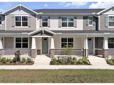 Charming townhome featuring a welcoming front porch with stone accents and beautifully manicured landscaping at 1273 Coral Bean Ln, Winter Springs, FL 32708
