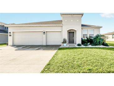 Two-car garage and well-maintained lawn characterize this home's exterior at 157 Pineywoods St, St Cloud, FL 34769