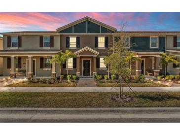 Two-story townhome with a charming front porch and landscaping at 2559 Relaxing Ln, Kissimmee, FL 34747