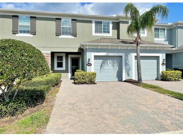 Exterior view of a two-story townhome with a two-car garage and landscaping at 2646 River Landing Dr, Sanford, FL 32771