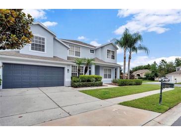 Two-story home with gray garage door and landscaped lawn at 2717 Treymore Dr, Orlando, FL 32825