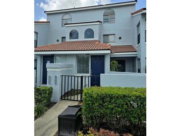 Inviting two-story condo with a red tile roof, blue painted stucco, and manicured landscaping at 4826 Marks Terrace # 389, Orlando, FL 32811