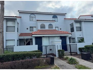 Charming townhome featuring a terracotta roof, black gate, and neutral-colored exterior at 4826 Marks Terrace # 389, Orlando, FL 32811