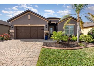 Beautiful single story home with manicured landscaping, a brick driveway and a two car garage at 508 Zamora Way, Davenport, FL 33837
