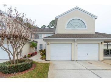 Two-story townhome with a two-car garage and landscaped walkway at 5999 Lake Pointe # 609, Orlando, FL 32822