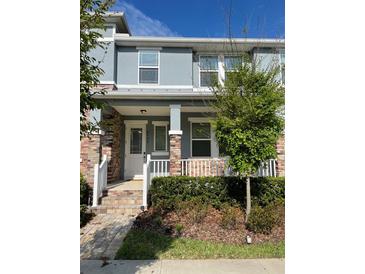 Charming two-story townhome with a cozy front porch and well-maintained landscaping in a suburban neighborhood at 8066 Glenlloyd Ave, Winter Garden, FL 34787