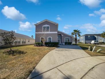 Two-story house with gray exterior, landscaping, and driveway at 812 Lockbreeze Dr, Davenport, FL 33897