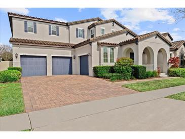 Charming two-story home boasts a three-car garage and a brick-paved driveway at 9573 Meadow Hunt Way, Winter Garden, FL 34787