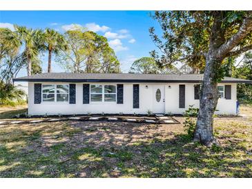 Charming ranch-style home with white exterior, black accents, and landscaped yard at 1021 Flagler Ave, Edgewater, FL 32132