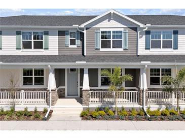 Charming townhome featuring stone accents, blue shutters and a covered porch with white railings at 1317 Coral Bean Ln, Winter Springs, FL 32708