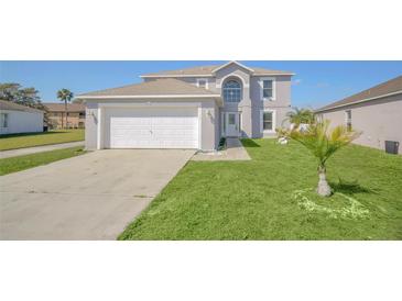 Charming two-story home featuring a well-maintained lawn and attached two-car garage at 2120 Marisol Loop, Kissimmee, FL 34743