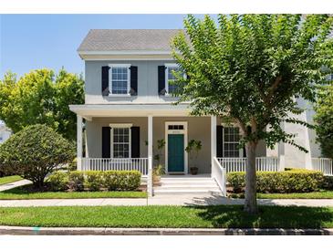 Two-story house with gray siding, black shutters, and a teal front door at 4006 Markham Pl, Orlando, FL 32814
