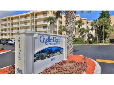 Condominium exterior view showcasing the building and signage, complemented by mature landscaping at 4175 S Atlantic Ave # 232, New Smyrna Beach, FL 32169