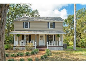 Charming two-story home featuring a welcoming front porch, lush landscaping, and a classic design at 632 Tildenville School Rd, Winter Garden, FL 34787