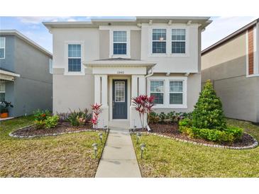 Charming two-story home with well-manicured landscaping and a welcoming walkway at 11842 Sunsail Ave, Orlando, FL 32832