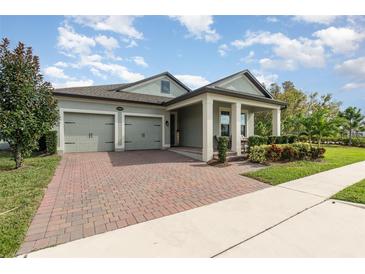 Inviting single-story home featuring a well-maintained front yard and brick-paved driveway leading to a two-car garage at 13557 Parkfield Way, Winter Garden, FL 34787