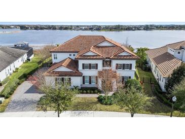 Luxury home with lake views, tile roof, and manicured landscaping at 15138 Shonan Gold Dr, Winter Garden, FL 34787